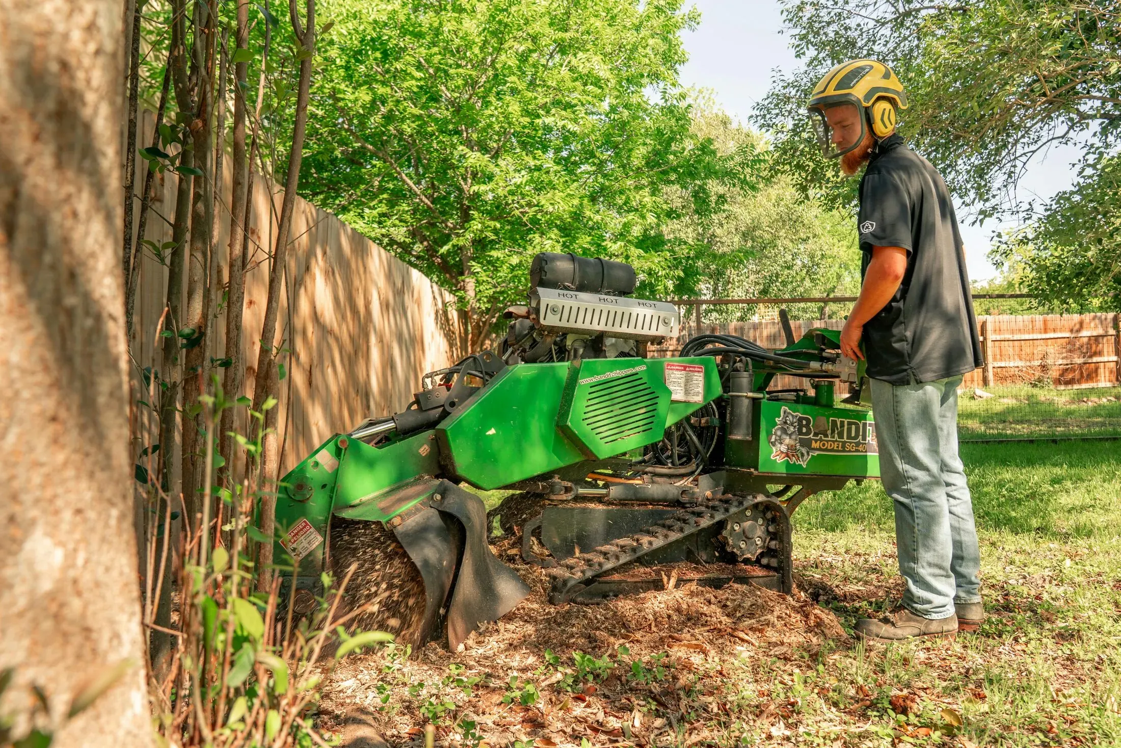 A stump-grinding machine parked beside a freshly ground tree stump